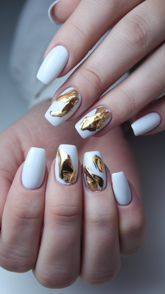 Nail design featuring a crisp white base with gold foil accents.