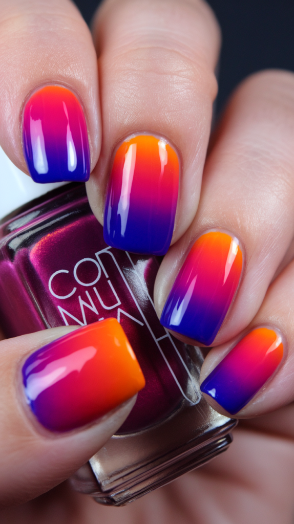 Colorful sunset gradient nail art with purple, orange, and pink shades.