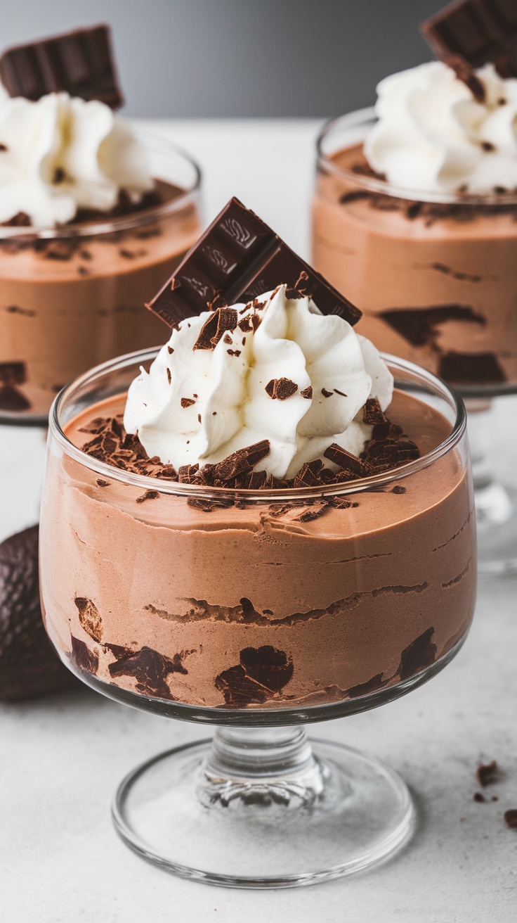 A delicious serving of chocolate avocado mousse topped with whipped cream and chocolate shavings.