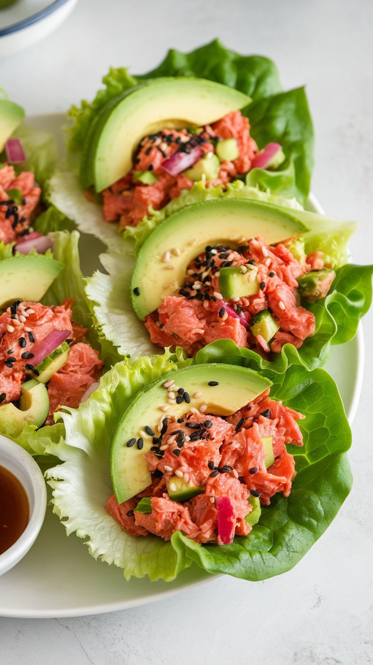 Spicy tuna salad served in lettuce wraps with avocado slices on top.